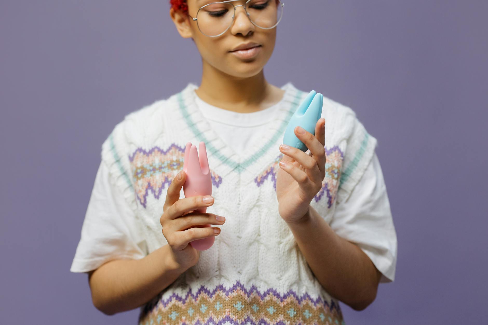 Woman holding blue and pink silicone vibrators, exploring pleasure after hormonal shifts