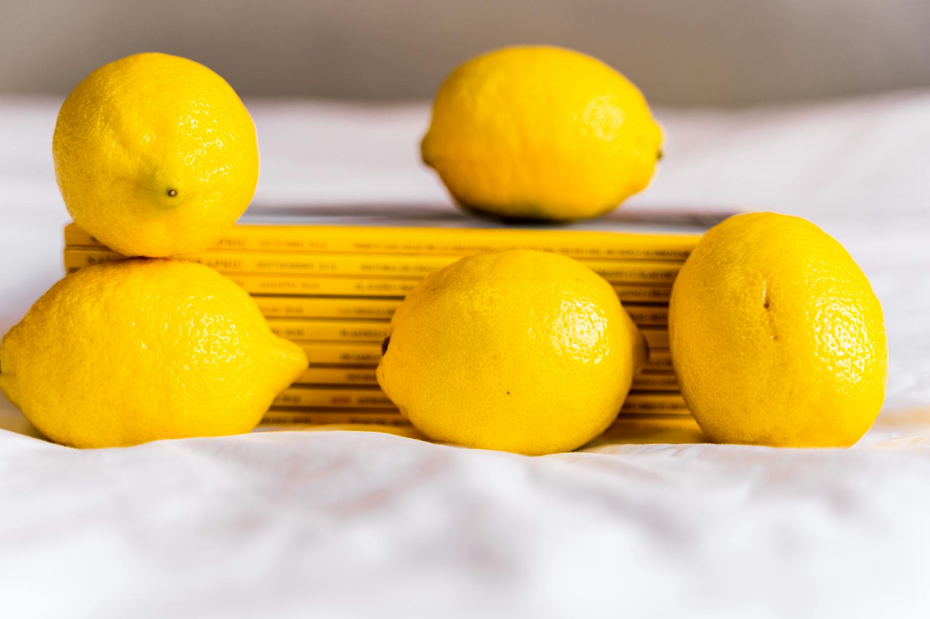 A bright yellow silicone vibrator surrounded by peeled bananas on a sunny yellow background